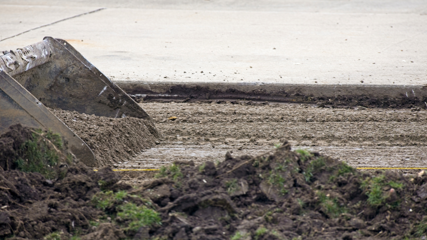 A pile of dirt sitting next to a road